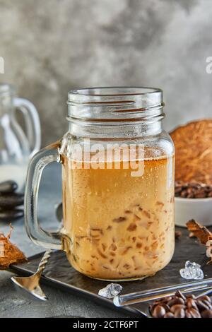 Thailändischer Eiskaffee mit Kokosmilch mit zerkleinertem Eis in einem Mason-Glas. Stockfoto