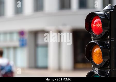 Verkehrssteuerungs-Semaphore mit Stoppleuchte auf unfokussem Stadthintergrund Stockfoto