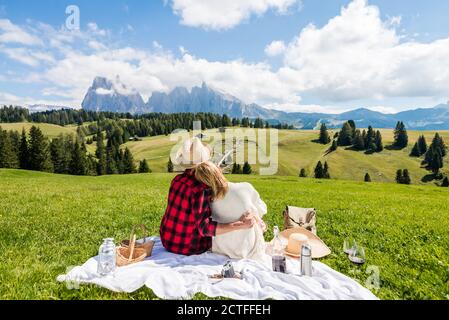 Romantisches Paar auf der Seiser Alm, Italien. Freund und Freundin in der Liebe genießen Picknick Zeit zusammen - heller Filter Stockfoto