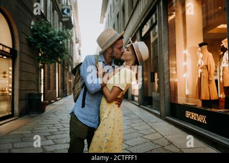Ein paar junge Touristen in der Liebe mit einem romantischen Kuss in der Stadt. Freund und Freundin haben einen besonderen romantischen Moment auf der Straße. Liebe, tou Stockfoto