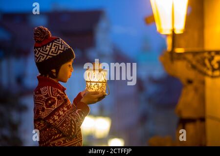 Schöne Vorschulkind, mit Laterne, lässig gekleidet, Blick auf Nacht Blick auf Prag Stadt, Winter Stockfoto