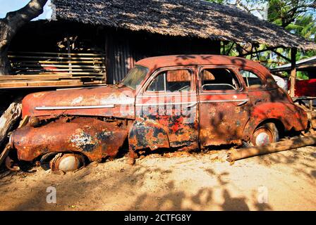 Rack eines rot gefärbten, rostigen Chevrolet-Autos der 50'ten, gestrandet an einem öffentlichen Strandbereich in Cuyo Town, Cuyo Islands, Palawan Province, Philippinen. Stockfoto