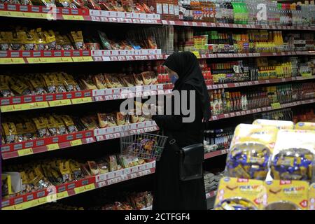 Gaza-Stadt. September 2020. Eine Palästinenserin, die am 22. September 2020 in einem Supermarkt in Gaza City eine Gesichtsmaske trägt. Palästina verzeichnete am Dienstag 557 neue Fälle, die mit dem neuartigen Coronavirus infiziert wurden, womit die Gesamtzahl der Infektionen auf 46,614 annahm. Im Gazastreifen hat die von der Hamas regierte Regierung kürzlich die Beschränkungen des Coronavirus gelockert. Kredit: Rizek Abdeljawad/Xinhua/Alamy Live Nachrichten Stockfoto