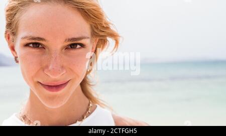 Porträt Nahaufnahme einer schönen jungen kaukasischen Frau im Freien am Strand Blick auf die Kamera. Stockfoto