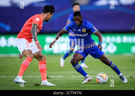 Ghanaischer Fußballspieler Mubarak Wakaso aus Jiangsu Suning F.C., rechts, schützt den Ball während des sechsten Spielrunde der 2020 Chinese Super League (CS Stockfoto