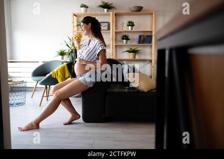 Schöne schwangere Frau essen gesund essen zu Hause Stockfoto