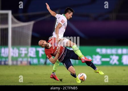 Der polnische Fußballspieler Adrian Mierzejewski von Chongqing SWM, vorne, fällt auf den Boden, nachdem er beim vierten Spiel von 2020 Chine getreten wurde Stockfoto