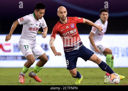 Der polnische Fußballspieler Adrian Mierzejewski von Chongqing SWM, rechts, schützt den Ball beim vierten Spiel der chinesischen Super League 2020 (CSL) Stockfoto