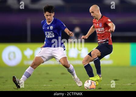 Der polnische Fußballspieler Adrian Mierzejewski von Chongqing SWM, rechts, schützt den Ball beim sechsten Spiel der chinesischen Super League 2020 (CSL) Stockfoto