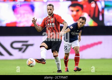 Der österreichische Fußballspieler Marko Arnautovic von Shanghai SIPG F.C., links, schützt den Ball beim siebten Spiel der chinesischen Super League 2020 ( Stockfoto