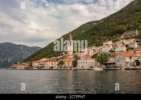 Perast historische Stadt in Kotor Bucht. Alte Stadt in Montenegro. Schöne Bucht mit alten Gebäuden, Cafés, Restaurants und geparkten Touristenautos. Stockfoto