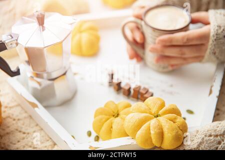 Herbststimmung, heiße Tasse Kaffee in den Händen der Frau im Pullover am Fenster Stockfoto