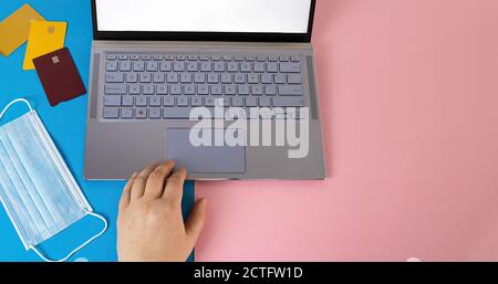 High-Angle-Aufnahme eines Laptops in der Nähe von Karten und ein Gesichtsmaske Stockfoto