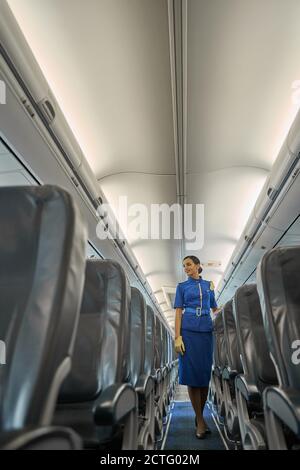 Eine fröhliche Stewardess, die bereit ist, die Passagiere willkommen zu heißen Stockfoto