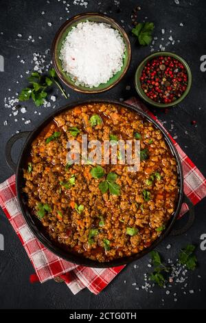 Bolognese steht in Eisenplatte am schwarzen Tisch. Stockfoto