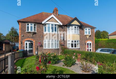 Große zweistöckige britische Doppelhaushälfte aus den 1930er Jahren aus Ziegelstein mit gebogenen Erkerfenstern in West Sussex, England, Großbritannien. Stockfoto