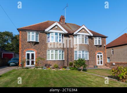 Große zweistöckige britische Doppelhaushälfte aus den 1930er Jahren aus Ziegelstein mit gebogenen Erkerfenstern in West Sussex, England, Großbritannien. Stockfoto