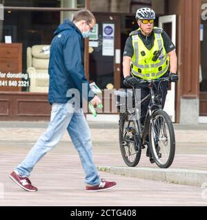 Ein Polizist ist auf der High Street aus dem Stadtzentrum von Paisley, die einschließlich anderer Städte in Renfrewshire, hat zusätzliche Lockdown Maßnahmen gegen Mitternacht letzte Nacht hinzugefügt entdeckt. Aufgrund eines Spikes in Covid-19 Fällen. Kredit: Euan Cherry Stockfoto