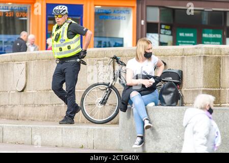 Ein Polizist ist auf der High Street aus dem Stadtzentrum von Paisley, die einschließlich anderer Städte in Renfrewshire, hat zusätzliche Lockdown Maßnahmen gegen Mitternacht letzte Nacht hinzugefügt entdeckt. Aufgrund eines Spikes in Covid-19 Fällen. Kredit: Euan Cherry Stockfoto