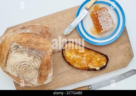 Sauerteig Toast mit Wabe auf einem Brottafel. VEREINIGTES KÖNIGREICH Stockfoto