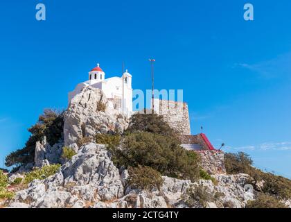 Weiße Kapelle von Agia Kyriaki mit kleiner roter Kuppel, auf einer Klippe, in der Nähe von Pigadia, Insel Karpathos, Griechenland Stockfoto