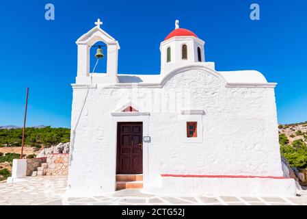 Weiße Kapelle von Agia Kyriaki mit kleiner roter Kuppel, auf einer Klippe, in der Nähe von Pigadia, Insel Karpathos, Griechenland Stockfoto