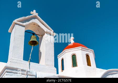 Weißer Glockenturm der Agia Kyriaki Kapelle, mit kleiner roter Kuppel, auf einer Klippe, in der Nähe von Pigadia, Insel Karpathos, Griechenland Stockfoto