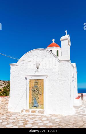 Weiße Kapelle von Agia Kyriaki mit kleiner roter Kuppel, auf einer Klippe, in der Nähe von Pigadia, Insel Karpathos, Griechenland Stockfoto