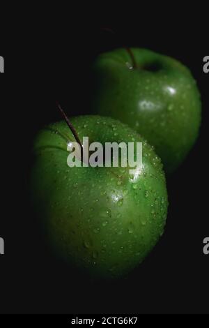 Apfelfrucht, abstrakter Schatten, schwarzer Hintergrund, grüner Apfel, Wassertropfen Stockfoto