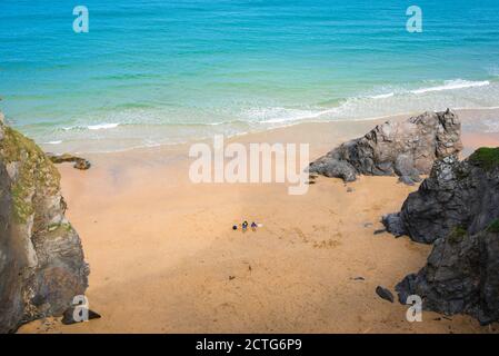 Strand für Paare allein, Blick auf ein junges Paar, das alleine an einem leeren Strand in Cornwall, England, liegt. Stockfoto