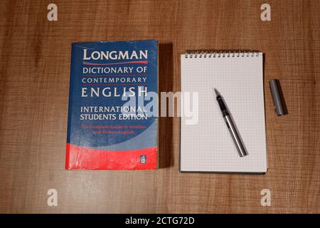 Ausstellung des englischen Wörterbuchs von Longman mit einem Notizbuch in der Nähe Schreibtisch Stockfoto