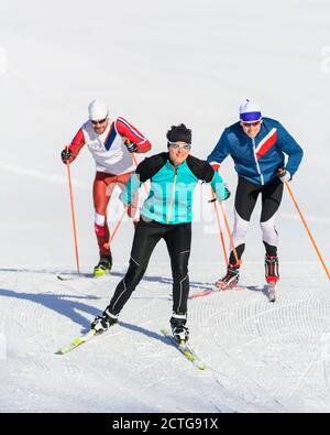 Drei junge Athleten machen Skating-Session auf winterlicher Piste Stockfoto