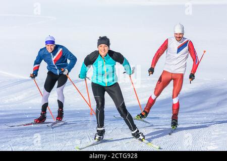 Drei junge Athleten machen Skating-Session auf winterlicher Piste Stockfoto