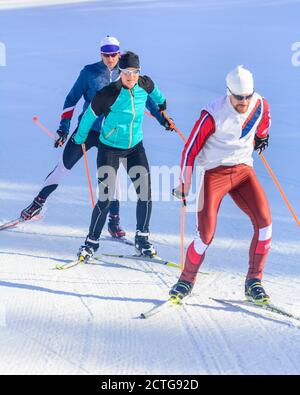 Drei junge Athleten machen Skating-Session auf winterlicher Piste Stockfoto