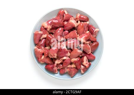 Roh frische Hühnerherzen in grau Platte auf weiß isoliert Hintergrund Draufsicht Flat Lay offal bereit für gesundes Kochen Essen Stockfoto