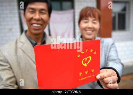 (200923) -- ZHENYUAN, 23. September 2020 (Xinhua) -- der Dorfbewohner Zhang Xiaohua (R) und ihr Mann Xue Jinzhang zeigen eine Bescheinigung, dass sie kein verarmter Haushalt mehr im Dorf Wuyuan der Gemeinde Xinji, Bezirk Zhenyuan, nordwestlich der Provinz Gansu, sind, 21. September 2020. Zhangs Familie wurde 2013 als verarmter Haushalt registriert. Im Jahr 2019 begann sie mit Unterstützung der lokalen Regierung Kaninchen und Ziegen zu züchten, die ihr Boni und Dividenden boten, während ihr Mann Xue Jinzhang einen Job in der Nähe von zu Hause bekam. Zhang Paar und ein paar andere im Dorf s Stockfoto