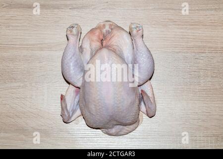 Eine obere Nahaufnahme eines ganzen Hähnchens auf Holzhintergrund. Isoliert. Stockfoto