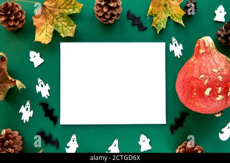 Herbstkomposition. Kürbisse, getrocknete Blätter und dekorative Ghoasts und Fledermäuse Hintergrund. Papier leere Vorlage Herbst, Herbst, halloween, Danksagung Stockfoto