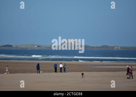 Menschen am Strand im Herbst Sonnenschein, Budle Bucht, Northumberland Stockfoto