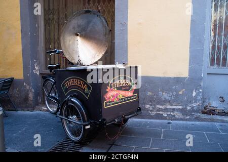 Lastenfahrrad eines "Socca" (lokale Lebensmittelspezialität) Händlers in einer kleinen alten Straße in Nizza im Sommer. Stockfoto