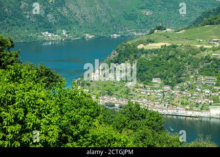Luftbild über Morcote mit Alpensee Lugano und Berg an einem sonnigen Tag im Tessin, Schweiz. Stockfoto