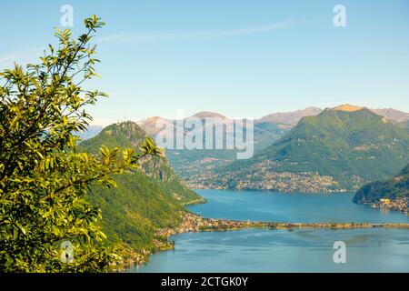 Luftbild Lugano mit Alpensee und Berg an einem sonnigen Tag im Tessin, Schweiz. Stockfoto