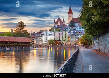 Thun, Schweiz. Stadtbild der schönen Stadt Thun mit der Reflexion der Stadt in der Aare Fluss bei Sonnenuntergang. Stockfoto