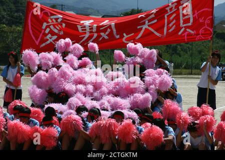 KIZUGAWA, JAPAN - Sep 17, 2010: Schüler der Mittelstufe in Japan führen während ihres Sporttages ein buntes Jubelprogramm mit einem Schild durch Stockfoto