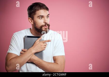 Mann wirbt eine Tablette auf einem rosa Hintergrund Codes Raum Beschnittene Ansicht der Emotionen weißes T-Shirt Modell neue Technologien Stockfoto