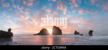 Küstenmeer. Sonnenuntergang. Wild Rock Beach. Die natürliche Felsformation. Rote Sonne über dem Sommermeer. Wolke auf einem blauen Himmel über dem Sommermeer. Berge in Koh Tao, Th Stockfoto