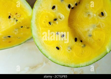 Wassermelone mit gelbem Fruchtfleisch, halbieren. Zwei Hälften einer gelben Wassermelone. Stockfoto