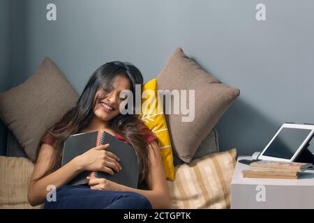 Frau lächelt mit einem Tagebuch in der Hand Stockfoto