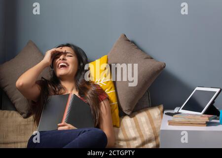 Frau lächelt mit einem Tagebuch in der Hand Stockfoto