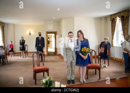 Ehepaar heiratet während der Coronavirus / Covid-19 Pandemie 2020 im St. Albans Register Office. Die Gäste tragen Gesichtsmasken und Gesichtsbezüge Stockfoto